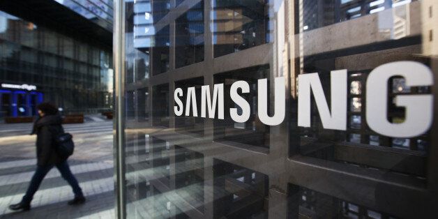 A woman walks past Samsung Electronics Co. signage outside the company's Seocho office building in Seoul, South Korea, on Friday, Feb. 17, 2017. Samsung Group's Jay Y. Lee was formally arrested on allegations of bribery, perjury and embezzlement, an extraordinary step that jeopardizes the executive's ascent to the top role at the world's biggest smartphone maker. Photographer: SeongJoon Cho/Bloomberg via Getty Images