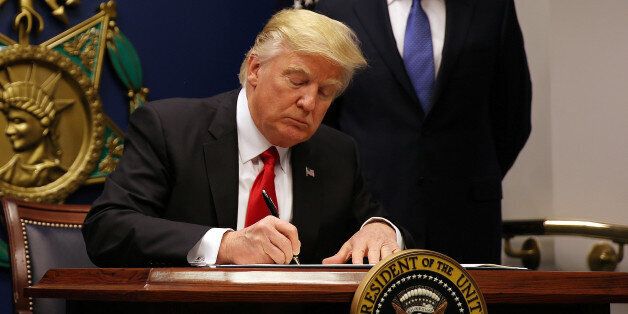 U.S. President Donald Trump signs a revised executive order for a U.S. travel ban on Monday, leaving Iraq off the list of targeted countries, at the Pentagon in Washington, U.S., January 27, 2017. REUTERS/Carlos Barria/FILE