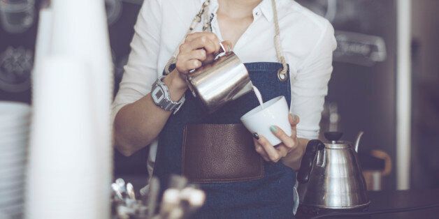Young barista is making a coffee