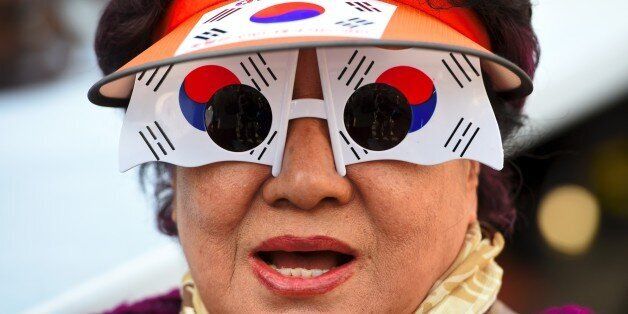 A supporter of South Korea's impeached-President Park Geun-Hye wears glasses painting the national flag during a rally opposing the impeachment in Seoul on March 11, 2017.South Korean President Park Geun-Hye was fired on March 10 as a court upheld her impeachment over a corruption scandal that has paralysed the nation at a time of mounting tensions in East Asia. / AFP PHOTO / JUNG Yeon-Je        (Photo credit should read JUNG YEON-JE/AFP/Getty Images)