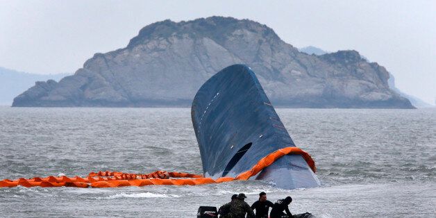 A vessel involved in salvage operations passes near the upturned South Korean ferry