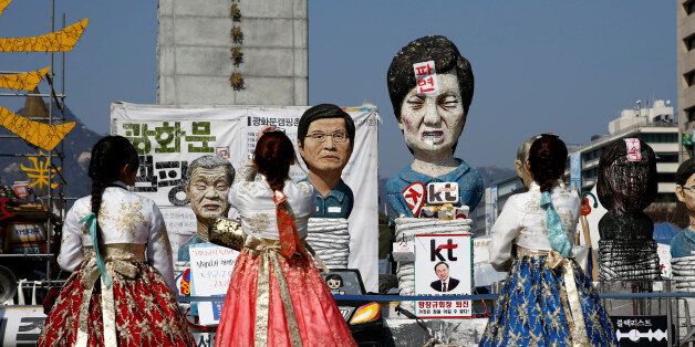 Tourists wearing traditional costume 'Hanbok' take picture of a statue depicting South Korea's ousted leader Park Geun-hye in Seoul, South Korea, March 13, 2017. REUTERS/Kim Kyung-Hoon