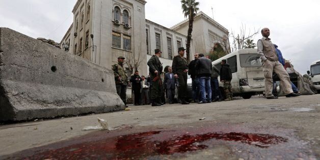 Syrian security forces cordon off the area following a reported suicide bombing at the old palace of justice building in Damascus on March 15, 2017.A suicide bomber attacked the courthouse in the centre of the Syrian capital, killing at least 25 people and wounding others, state media reported. / AFP PHOTO / Louai Beshara        (Photo credit should read LOUAI BESHARA/AFP/Getty Images)