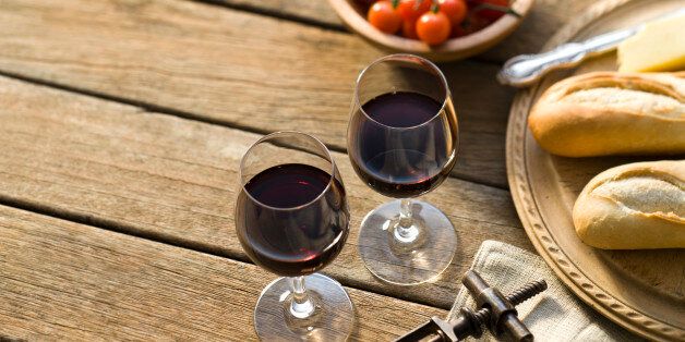 Red wine on a rustic picnic table.More rustic outdoor wine shots: