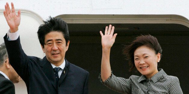 Japan's Prime Minister Shinzo Abe (L) and his wife Akie wave before boarding an aircraft as they depart Tokyo's Haneda airport to attend the meeting of Asia-Pacific Economic Coorpoeration (APEC) leaders' summit in Sydney September 7, 2007. With its cabinet jolted by scandals and the opposition in control of parliament's upper house, Japan faces a policy vacuum that bodes ill for fixing creaking social welfare systems or loosening the government's grip on the economy. REUTERS/Kyodo (JAPAN) JAPAN