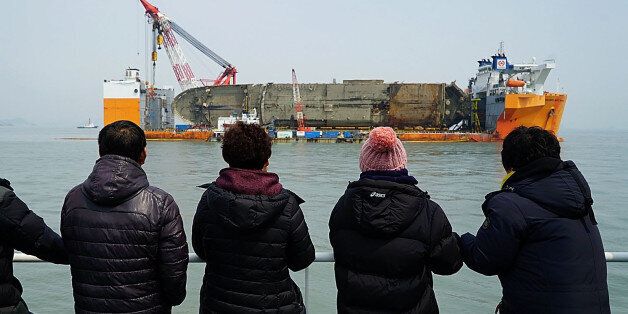 JINDO-GUN, SOUTH KOREA - MARCH 28: In this handout photo released by the South Korean Ministry of Oceans and Fisheries, Relatives of the missing victims look at a Sewol ferry on March 28, 2017 in Jindo-gun, South Korea. The Sewol sank off the Jindo Island in April 2014 leaving more than 300 people dead and nine of them still remain missing. Workers are in the process of an attempt to raise the ferry from the water in the hope that the disasters' final victims will be found. The Oceans Ministry says remains presumed to be of a victim of the Sewol ferry sinking have been found at the salvage site.  (Photo by South Korean Ministry of Oceans and Fisheries via Getty Images)