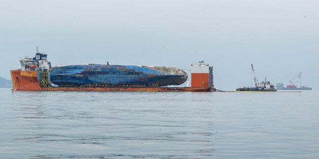 The sunken ferry Sewol is seen on a semi-submersible transport vessel during the salvage operation in waters off Jindo, South Korea. Salvage crews towed the corroded 6,800-ton South Korean ferry and loaded it onto a semi-submersible transport vessel Saturday, completing what was seen as the most difficult part of the massive effort to bring the ship back to shore nearly three years after it sank. / KOREAN MINISTRY OF OCEANS AND FISHERIES