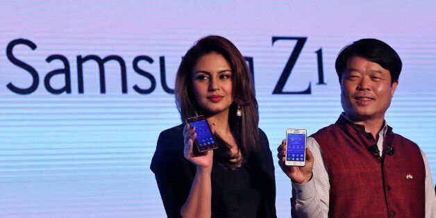 Hyun Chil Hong (R), president and chief executive of Samsung India Electronics, and Bollywood actress Huma Qureshi hold the Samsung?s new Z1 smartphones at its launch in New Delhi January 14, 2015. South Korea's Samsung Electronics Co Ltd has launched the first smartphone powered by its Tizen operating system, a major development in the tech giant's aim to build a software ecosystem to rival Google Inc's Android.   REUTERS/Adnan Abidi (INDIA - Tags: BUSINESS TELECOMS ENTERTAINMENT SCIENCE TECHNO
