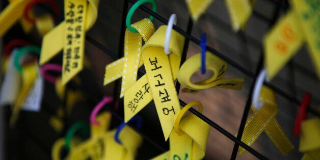 Yellow ribbons dedicated to the victims of the Sewol ferry disaster are seen hung on a fence in central Seoul November 11, 2014. The captain of the South Korean ferry that capsized in April killing 304 passengers was jailed for 36 years on Tuesday after a court found him guilty of negligence, but was acquitted of homicide for which prosecutors had sought the death penalty. The words on the ribbon (C) read,