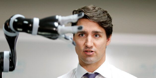 Canadian Prime Minister Justin Trudeau controls a robotic arm as he takes part in a robotics demonstration at Kinova Robotics in Boisbriand, Quebec, Canada March 24, 2017.  REUTERS/Christinne Muschi