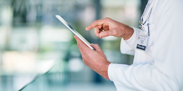 Cropped shot of a medial practitioner using his digital tablet