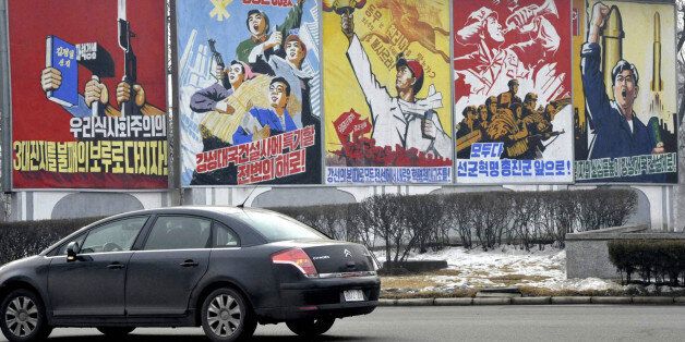 A car passes propaganda billboards hailing economic projects and the military along a roadway in Pyongyang December 21, 2010. REUTERS/Kyodo (NORTH KOREA - Tags: SOCIETY POLITICS) JAPAN OUT. NO COMMERCIAL OR EDITORIAL SALES IN JAPAN. FOR EDITORIAL USE ONLY. NOT FOR SALE FOR MARKETING OR ADVERTISING CAMPAIGNS. THIS IMAGE HAS BEEN SUPPLIED BY A THIRD PARTY. IT IS DISTRIBUTED, EXACTLY AS RECEIVED BY REUTERS, AS A SERVICE TO CLIENTS