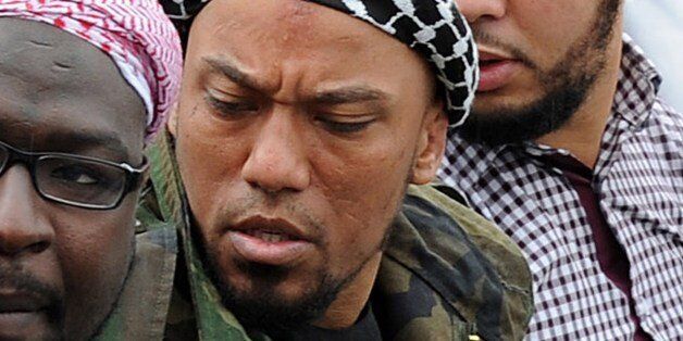 Picture taken on May 5, 2012 shows former German rapper Denis Cuspert (C) among salafi in Bonn, Germany. Denis Mamadou Cuspert, who rapped under the name Deso Dogg but took on the name Abu Talha al-Almani in Syria, was initially reported to have been killed in a suicide attack Sunday in an eastern province but hours later some retracted the claim, saying he was still alive. AFP PHOTO /DPA/  HENNING KAISER  GERMANY OUT        (Photo credit should read HENNING KAISER/AFP/Getty Images)