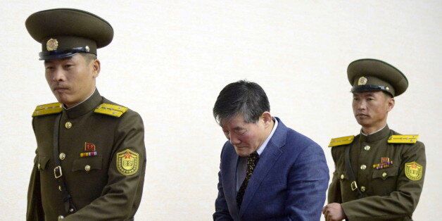 A man (C) who identified himself as Kim Dong Chul, previously said he was a naturalised American citizen and was arrested in North Korea in October, leaves after a news conference in Pyongyang, North Korea, in this photo released by Kyodo March 25, 2016. The Korean-American man who had been detained in North Korea has confessed to trying to steal military secrets from the isolated state, Japan's Kyodo and China's Xinhua news agencies reported on Friday. Mandatory credit REUTERS/Kyodo ATTENTION E