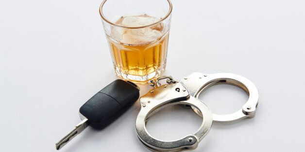 Handcuffs, keys and glass of alcohol on ice with copy space