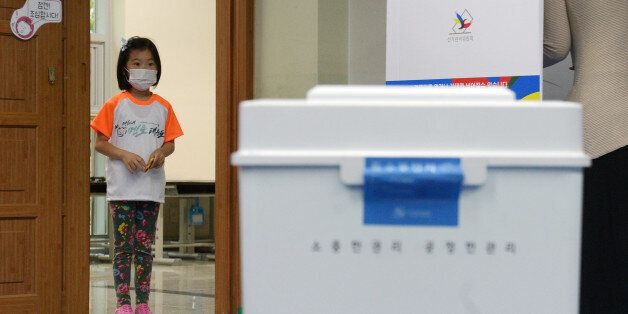 제19대 대통령 선거일인 9일 경기 고양시 신원초등학교에 마련된 투표소에서 한 어린이가 투표함을 바라보고 있다.