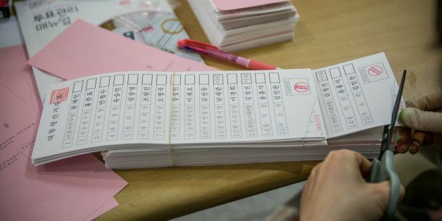 SEOUL, SOUTH KOREA - MAY 09:  A South Korean polling worker organizes voting papers before giving out to voters at a polling site on the presidential election on May 9, 2017 in Seoul, South Korea. Polls have opened in South Korea's presidential election, called seven months early after former President Park Geun-hye was impeached for her involvement in a corruption scandal.  (Photo by Jean Chung/Getty Images)