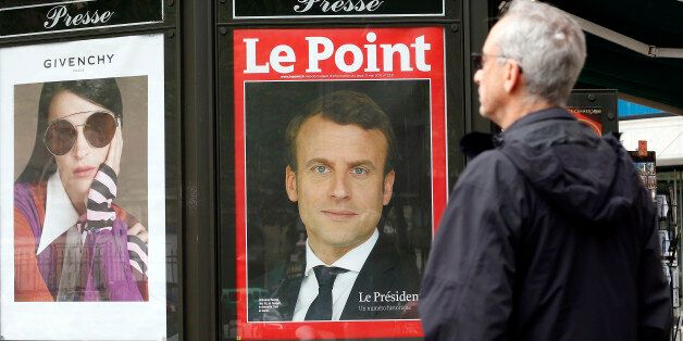 PARIS, FRANCE - MAY 08:  A man walks past the poster of the French magazine front cover 'Le Point' with the picture of the newly elected French president Emmanuel Macron a day after the second round of the French Presidential election on May 08, 2017 in Paris, France. Macron was elected President of the French Republic on May 07, 2017 with 66,1 % of the votes cast.  (Photo by Chesnot/Getty Images)