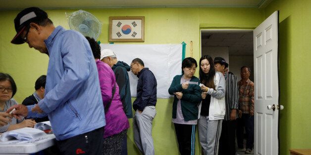 People cast their votes at a polling station during the presidential elections in Seoul, South Korea May 9, 2017. REUTERS/Kim Hongji