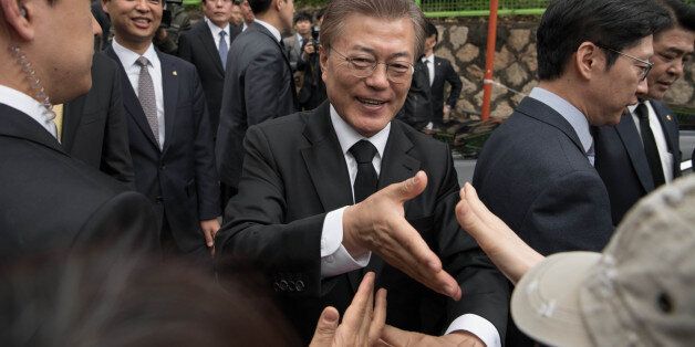 South Korean President Moon Jae-In greets supporters outside his home Seoul on May 10, 2017.Left-leaning former human rights lawyer Moon Jae-In began his five-year term as president of South Korea following a landslide election win after a corruption scandal felled the country's last leader.  / AFP PHOTO / Ed JONES        (Photo credit should read ED JONES/AFP/Getty Images)