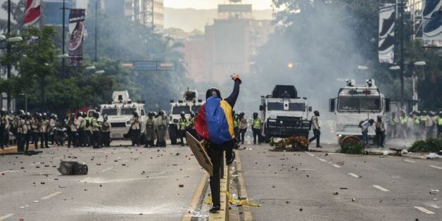 Riot police clash with demonstrators during a protest against the government of President Nicolas Maduro in Caracas on May 20, 2017. Venezuelan protesters and supporters of embattled President Nicolas Maduro take to the streets Saturday as a deadly political crisis plays out in a divided country on the verge of paralysis. / AFP PHOTO / FEDERICO PARRA        (Photo credit should read FEDERICO PARRA/AFP/Getty Images)