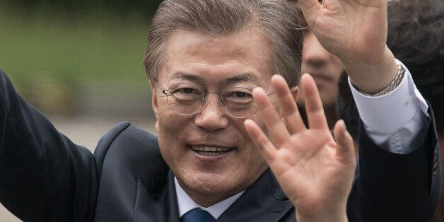 South Korea's President Moon Jae-In waves to his supporters as he greets members of staff as he arrives near the presidential Blue House in Seoul on May 10, 2017.Left-leaning former human rights lawyer Moon Jae-In began his five-year term as president of South Korea following a landslide election win after a corruption scandal felled the country's last leader.  / AFP PHOTO / Ed JONES        (Photo credit should read ED JONES/AFP/Getty Images)