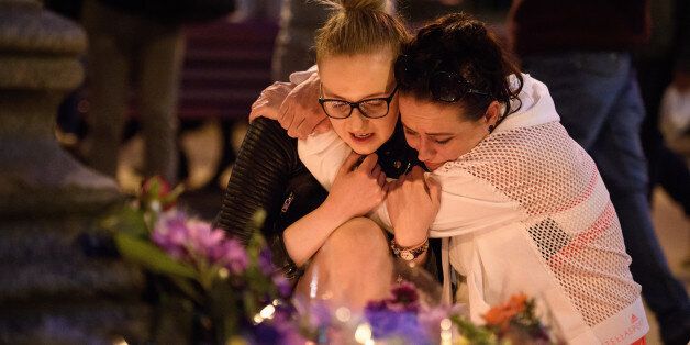 MANCHESTER, ENGLAND - MAY 23:  A woman is consoled as she looks at the floral tributes following an evening vigil outside the Town Hall on May 23, 2017 in Manchester, England. An explosion occurred at Manchester Arena as concert goers were leaving the venue after Ariana Grande had performed. Greater Manchester Police are treating the explosion as a terrorist attack and have confirmed 22 fatalities and 59 injured.  (Photo by Leon Neal/Getty Images)