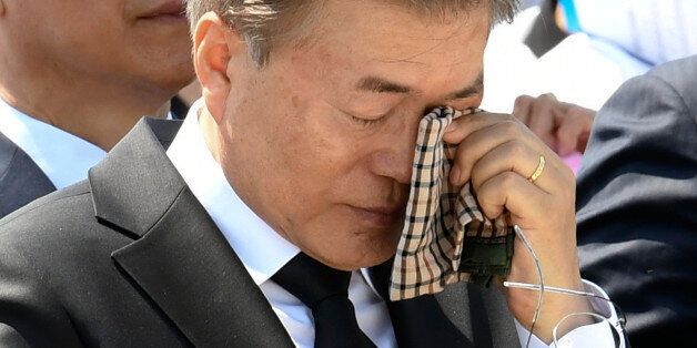 South Korean President Moon Jae-in wipes a tear from his eyes during the annual Democratic uprising memorial at the Gwangju National Cemetery, in the southwestern city of Gwangju on May 2017, as the government holds an annual ceremony to mark the 37th anniversary of a pro-democracy uprising. Moon commemorated the anniversary of the 1980 pro-democracy uprising in the city of Gwangju where hundreds of protestors were killed by the military. / AFP PHOTO / POOL / Kim Min-Hee        (Photo credit sho