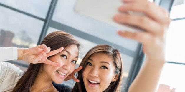 Asian women taking a selfie with a mobile phone