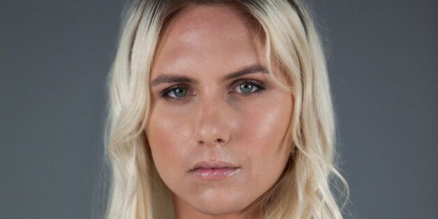 Portrait of transgender woman standing over gray background