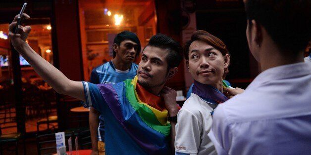 Members of the LGBT community in Thailand take photos as they gather in Bangkok on June 18, 2016 to take part in a vigil for victims of the worst mass shooting in modern US history in Orlando, Florida.Forty-nine people were killed and 53 wounded when a 29-year-old man ran amok in a packed gay nightclub early on June 12 in Orlando, armed with a legally bought assault rifle. / AFP / LILLIAN SUWANRUMPHA        (Photo credit should read LILLIAN SUWANRUMPHA/AFP/Getty Images)