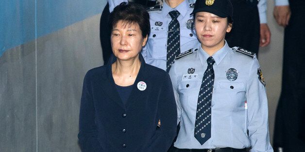 Park Geun-hye, former president of South Korea, left, is escorted by prison officers as she arrives at the Seoul Central District Court in Seoul, South Korea, on Tuesday, May 23, 2017. South Korean prosecutors arrested Park over allegations that she abused her powers and colluded with her longtime friend and former aides to get bribes from the nation's top businesses. Photographer: SeongJoon Cho/Bloomberg via Getty Images