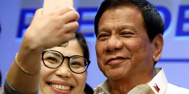 A journalist takes a selfie with Philippine President Rodrigo Duterte after a news conference in Manila, Philippines April 29, 2017.  REUTERS/Erik De Castro