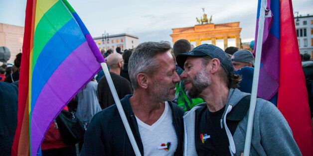 Two men kiss in front of Brandenburg Gate during an evening vigil in Berlin, Germany on June 18, 2016. Mourners gathered to commemorate the victims of a shooting at the gay nightclub 'Pulse' in Orlando, Florida, happened nearly a week earlier, in front of Brandenburg Gate enlightened with the LGBT rainbow colours. Fifty people died in the massacre and about fiftythree injured. (Photo by Emmanuele Contini/NurPhoto via Getty Images)