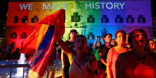 People celebrate in front of the rainbow-colour lit Auberge de Castille, the office of Prime Minister Joseph Muscat, after the Maltese parliament voted to legalise same-sex marriage on the Roman Catholic Mediterranean island, in Valletta, Malta, July 12, 2017.  REUTERS/Darrin Zammit Lupi
