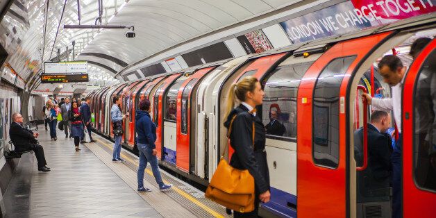 London, UK - April 22, 2015: People waiting at underground tube platform for train arrives