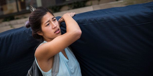 NEW YORK, NY - SEPTEMBER 05:  Emma Sulkowicz, a senior visual arts student at Columbia University, carries a mattress in protest of the university's lack of action after she reported being raped during her sophomore year on September 5, 2014 in New York City. Sulkowicz has said she is committed to carrying the mattress everywhere she goes until the university expels the rapist or he leaves. The protest is also doubling as her senior thesis project.  (Photo by Andrew Burton/Getty Images)