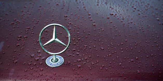 'Padua, Italy - July 6, 2011: Mercedes classical logo on a wet car hood. Mercedes-Benz, a division of Daimler AG, is a German manufacturer of automobiles, buses, coaches, and trucks. The name traces its origins to Daimler 1901 Mercedes and to Karl Benz 1886 Benz Patent Motorwagen, widely regarded as the first automobile. Mercedes today is synonymous with luxury, sportiness and technical reliability. Shot in a public parking.'
