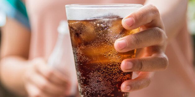 Woman hand giving glass of cola.Glass of cola ,Soft drinks with ice.