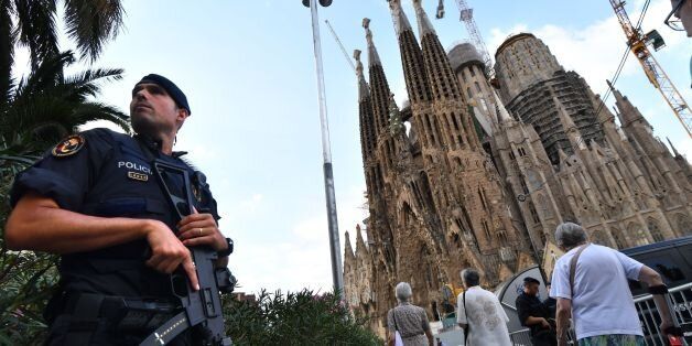 TOPSHOT - A police officer stands by the Sagrada Familia basilica in Barcelona on August 20, 2017, before a mass to commemorate victims of two devastating terror attacks in Barcelona and Cambrils.A grief-stricken Barcelona prepared today to commemorate victims of two devastating terror attacks at a mass in the city's Sagrada Familia church. As investigators scrambled to piece together the attacks which killed 14 people in all, Interior Minister Juan Ignacio Zoido said on August 19 the cell behin