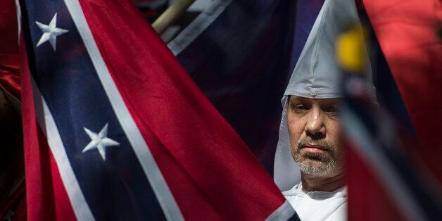 A member of the Ku Klux Klan looks on during a rally, calling for the protection of Southern Confederate monuments, in Charlottesville, Virginia on July 8, 2017.The afternoon rally in this quiet university town has been authorized by officials in Virginia and stirred heated debate in America, where critics say the far right has been energized by Donald Trump's election to the presidency. / AFP PHOTO / ANDREW CABALLERO-REYNOLDS        (Photo credit should read ANDREW CABALLERO-REYNOLDS/AFP/Getty