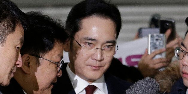 Lee Jae-yong (C) vice chairman of Samsung Electronics, arrives to be questioned as a suspect in a corruption scandal that led to the impeachment of President Park Geun-Hye, at the office of the independent counsel in Seoul on January 12, 2017. / AFP / POOL / AHN Young-Joon        (Photo credit should read AHN YOUNG-JOON/AFP/Getty Images)