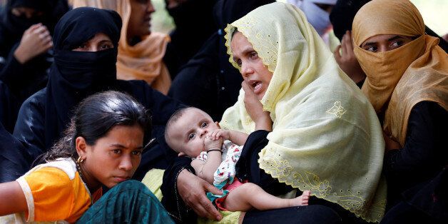 A Rohingya refugee woman with a child talks over phone as she takes shelter in No Manâs Land between Bangladesh-Myanmar border, in Coxâs Bazar, Bangladesh, August 27, 2017. REUTERS/Mohammad Ponir Hossain