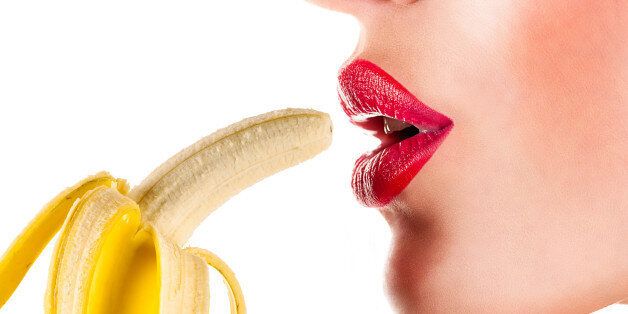 sexy woman eating banana isolated on white background