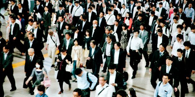A busy pedestrian walkway, businessmen and women, walking to work, motion blurred, Tokyo. Horizontal composition.