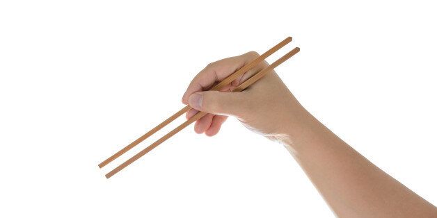 hand holding chopsticks, isolated on white background with clipping path