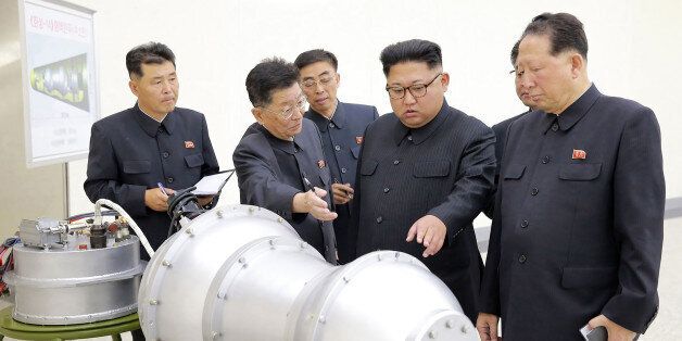 TOPSHOT - This undated picture released by North Korea's official Korean Central News Agency (KCNA) on September 3, 2017 shows North Korean leader Kim Jong-Un (C) looking at a metal casing with two bulges at an undisclosed location.North Korea has developed a hydrogen bomb which can be loaded into the country's new intercontinental ballistic missile, the official Korean Central News Agency claimed on September 3. Questions remain over whether nuclear-armed Pyongyang has successfully miniaturised
