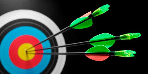 Three arrows in a target, scoring a bulls eye. Differential focus