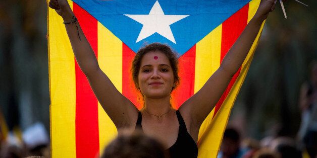 BARCELONA, SPAIN - SEPTEMBER 21:  A demonstrator holding a Catalan Pro-Independence flag 'Estelada' demonstrates in front of the Catalan High Court building on September 21, 2017 in Barcelona, Spain. Pro-Independence Associations called for a meeting in front of the Catalan High Court building demanding release of the 14 officials arrested yesterday during a Spanish Police operation in an attempt to stop the region's independence referendum, due to take place on October 1, which has been deemed