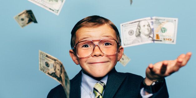 A young boy accountant wearing glasses catches U.S. currency while more falls from above. He is smiling and ready to do your taxes for the IRS and make your tax refund bigger.